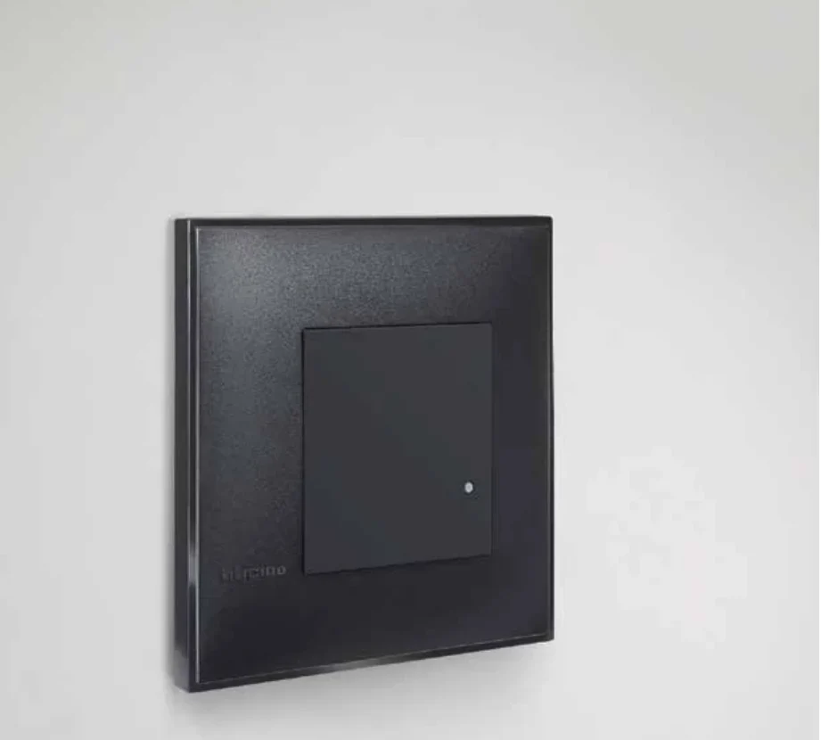 Черен ключ bticino Classia с бяла LED точка на светла стена