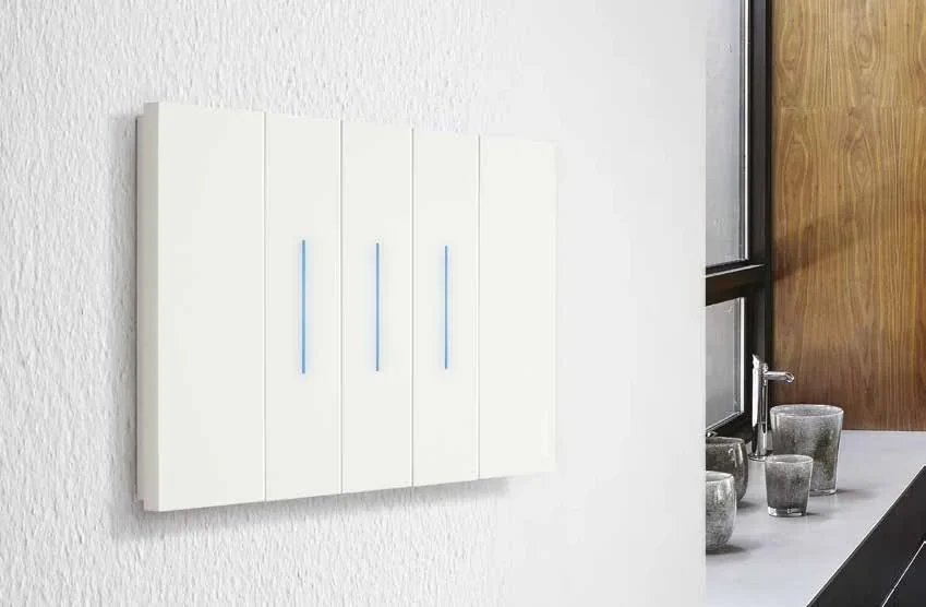 Бял ключ bticino Living Now with Netatmo със сини LED индикатори на стена в кухня